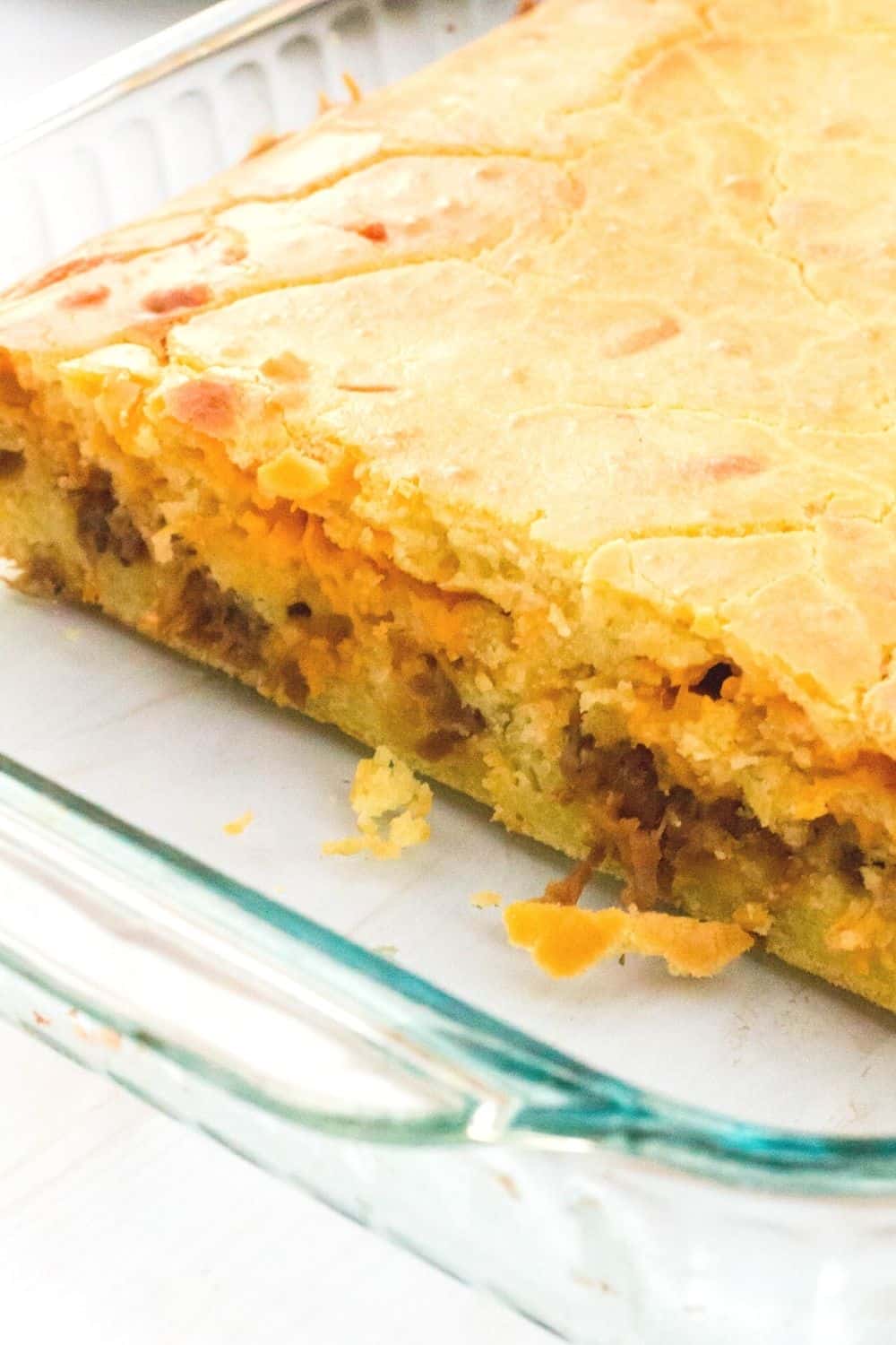 a glass Pyrex pan with freshly baked bola de carne, a Portuguese recipe using bread, meat, and cheese.