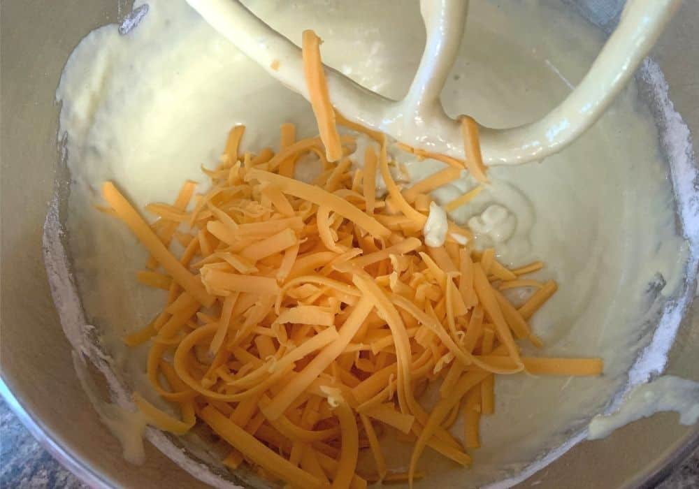 shredded cheddar cheese added to the bread batter for bola de carne