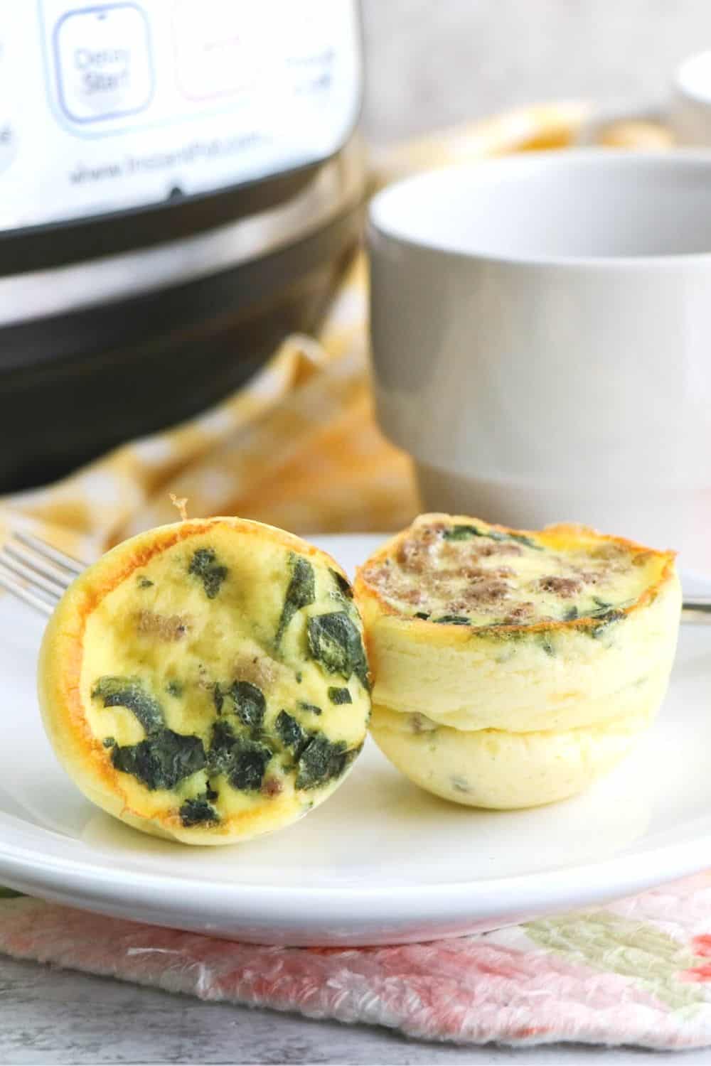 two pressure cooker egg bites filled with spinach and sausage crumbles.