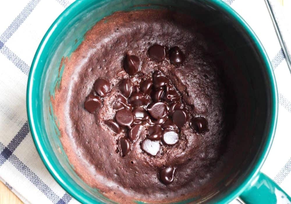 Warm chocolate mug cake cooked in the Instant Pot, topped with melty chocolate chips
