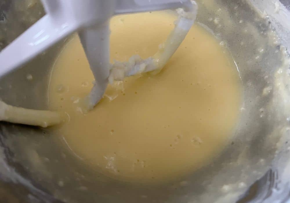 eggs and vanilla mixed into the butter, sugar, and sour cream mixture in the bowl of a stand mixer