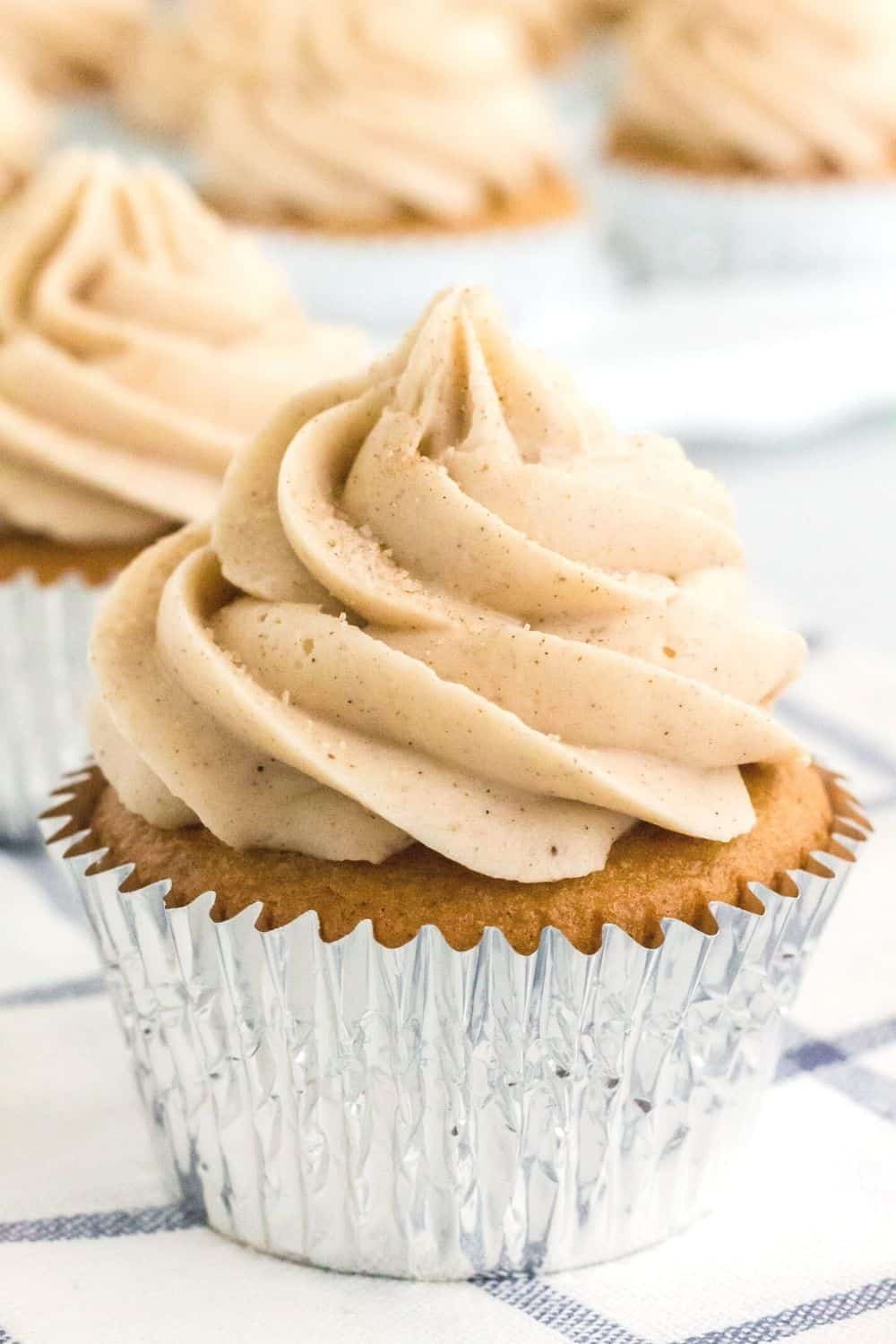 churro cupcake topped with cinnamon cream cheese frosting and a sprinkling of cinnamon sugar