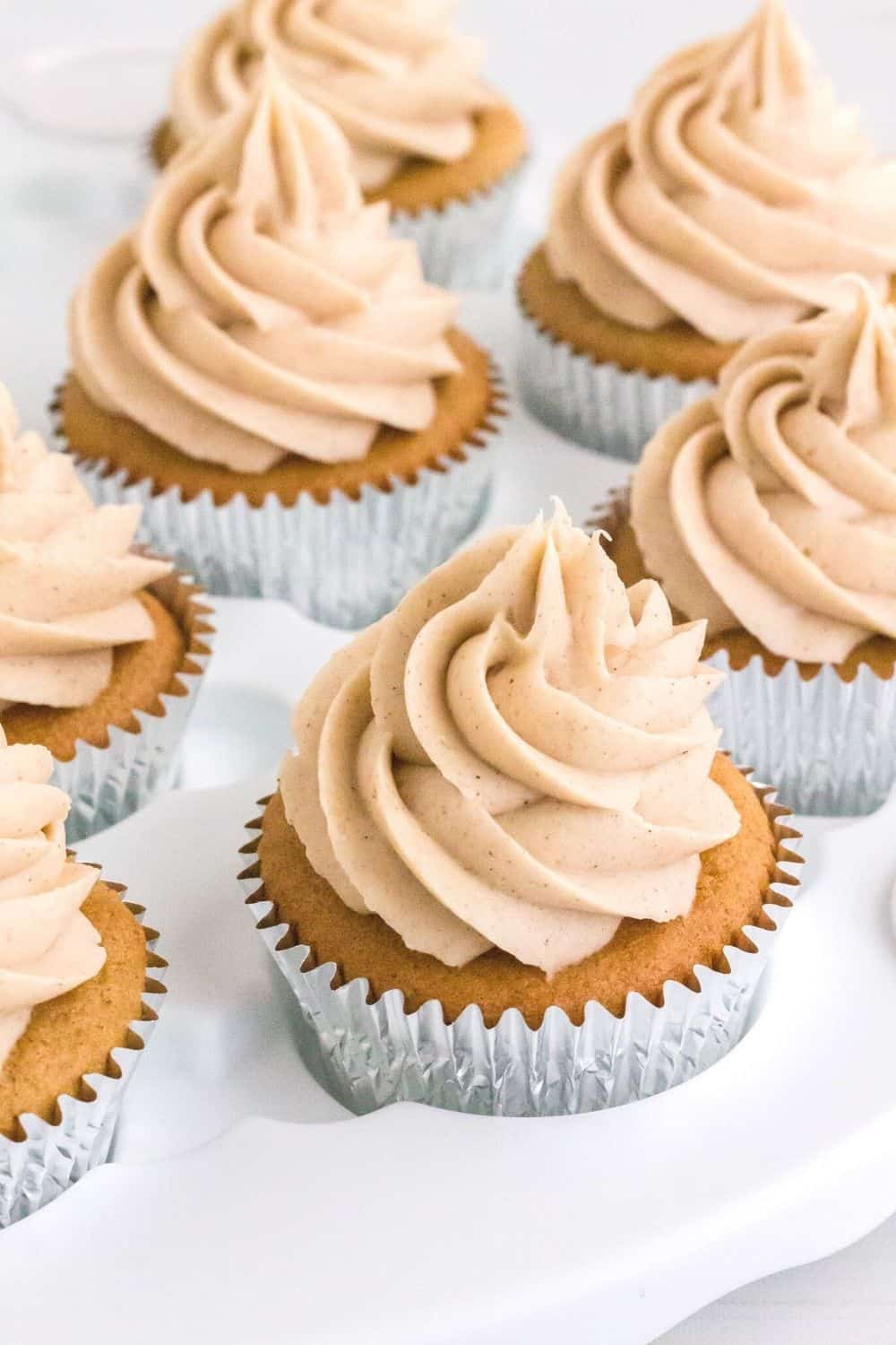 several churro cupcakes made with cake mix are displayed in a white cupcake platter