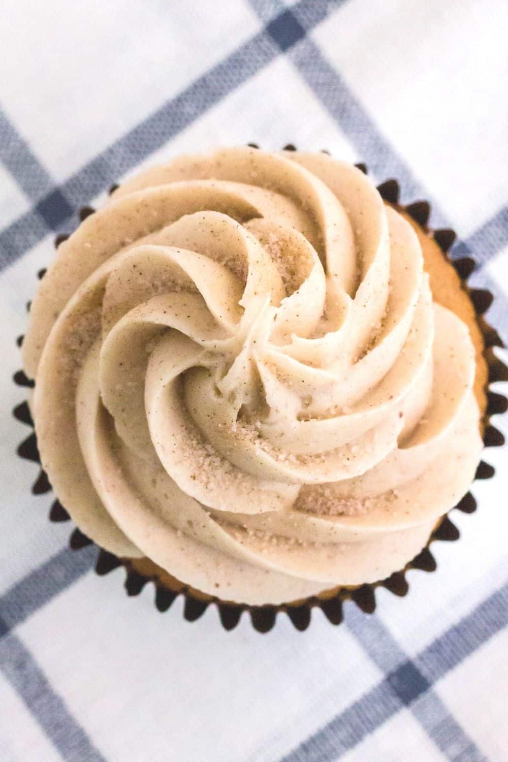 overhead view of the cinnamon cream cheese frosting topping a churro cupcake