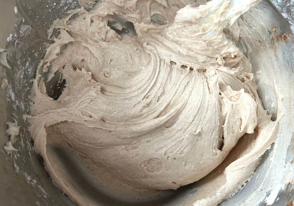 cinnamon cream cheese frosting in a mixing bowl, ready to be piped onto churro cupcakes