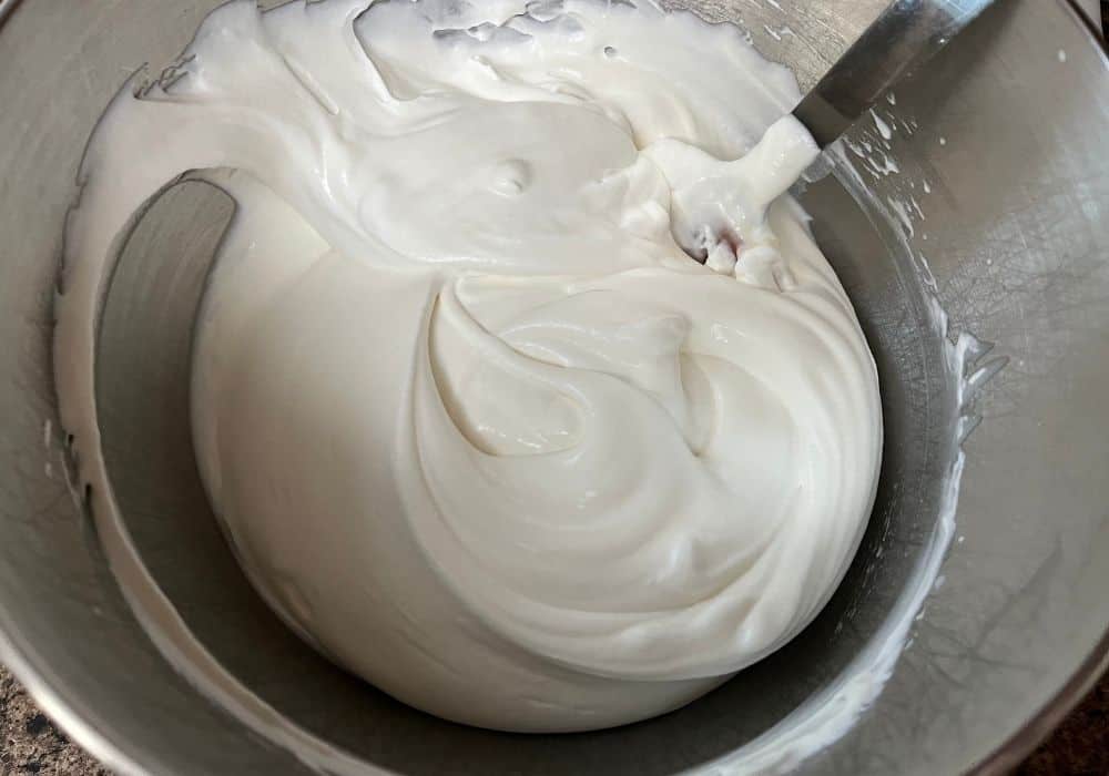 sweetened condensed milk folded into the whipped cream, creating the sweet cream base for speculoos ice cream