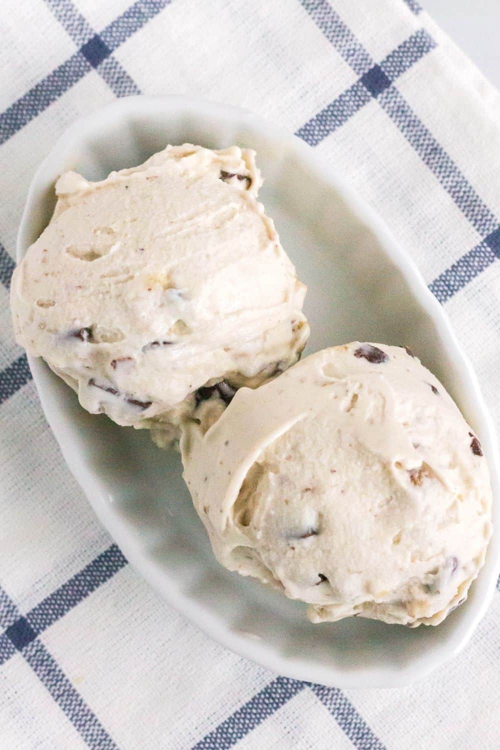 two scoops of copycat chunky monkey ice cream in a white ramekin.