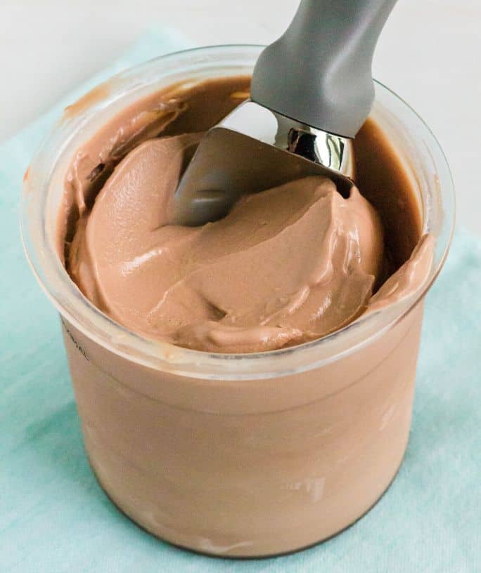 a pint of Ninja Creami chocolate ice cream with a scoop in it