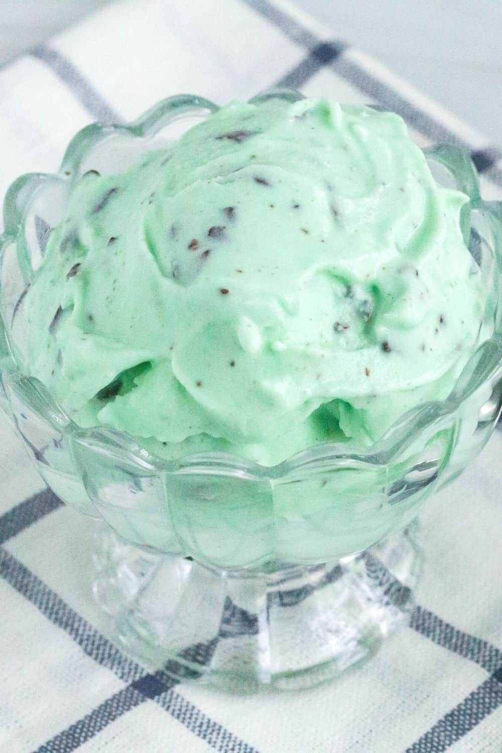a scoop of Ninja Creami mint chip ice cream in a glass dessert cup.