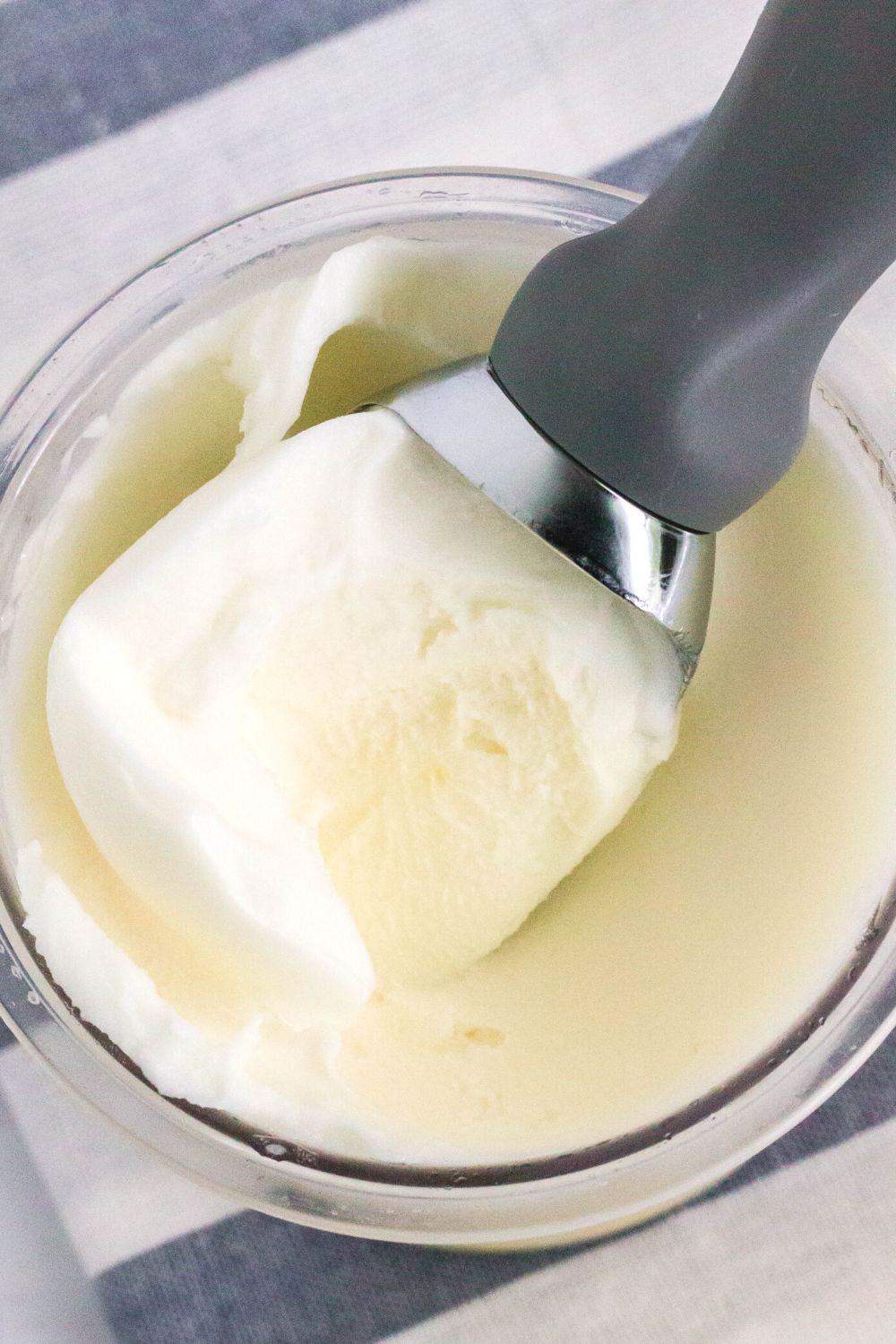 an ice cream scoop is scooping out some pineapple sorbet for serving