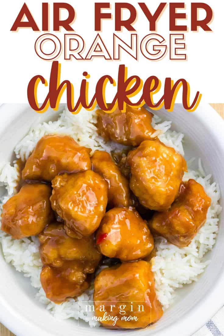 white bowl filled with air fryer orange chicken served over a bed of white rice.