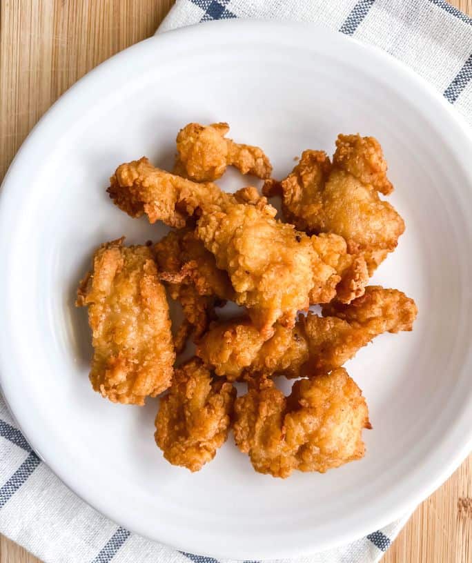 air fryer frozen chicken nuggets cooked and served on a white plate