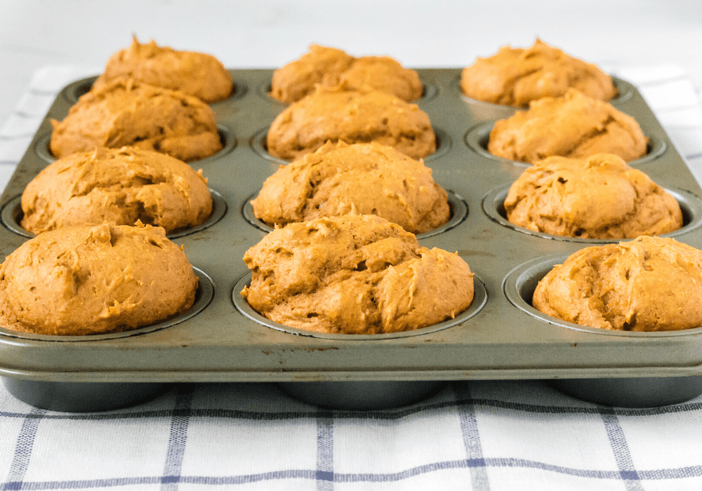 side view of a pan of pumpkin muffins fresh out of the oven