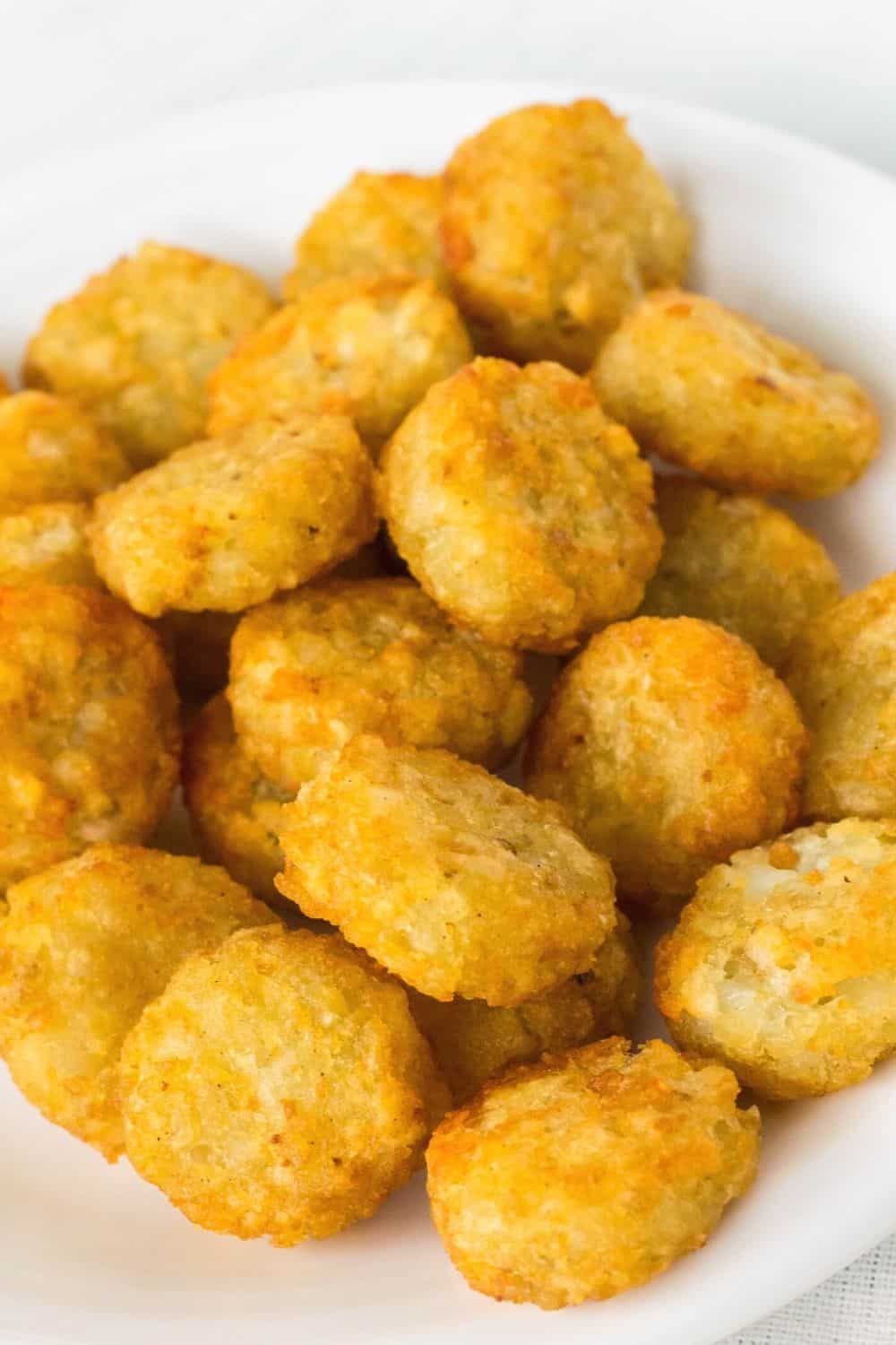 close-up view of air fried golden Crispy Crowns in a pile on a white plate