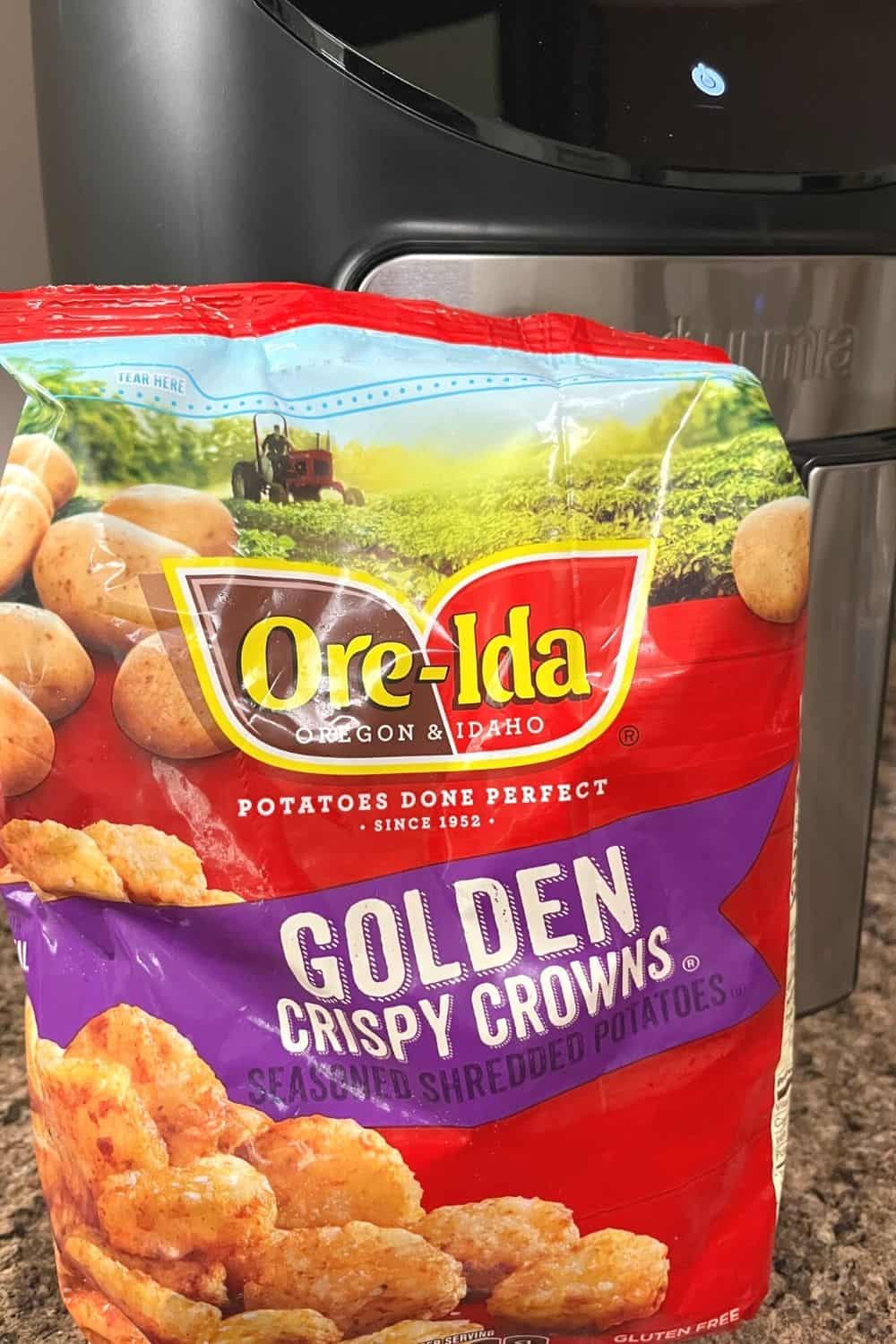 A bag of Ore Ida Golden Crispy Crowns in front of an air fryer