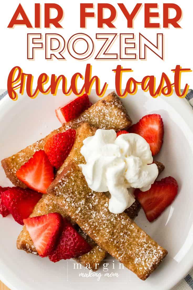 overhead view of several frozen french toast sticks that were cooked in the air fryer, topped with strawberries and whipped cream