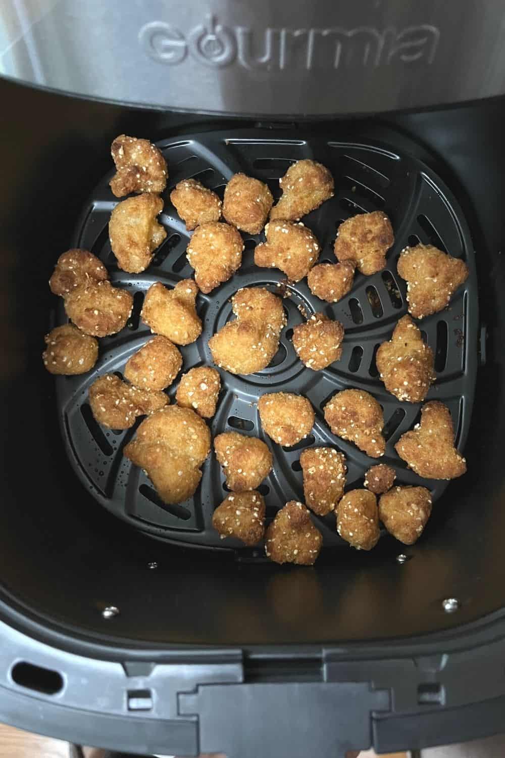 cooked cauliflower wings in the basket of an air fryer