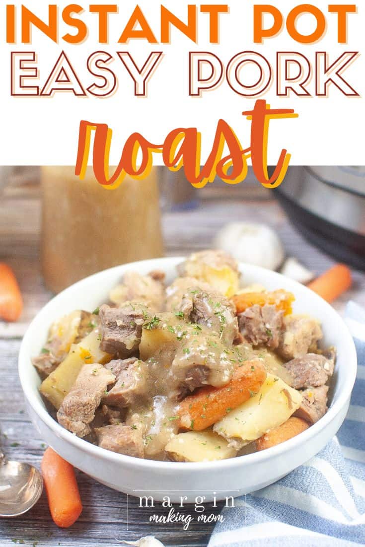 white bowl filled with Instant Pot pork roast, potatoes, and carrots topped with gravy