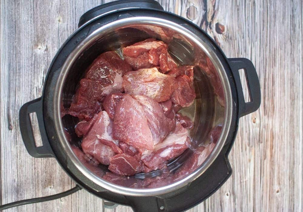 pork roast pieces being seared in instant pot