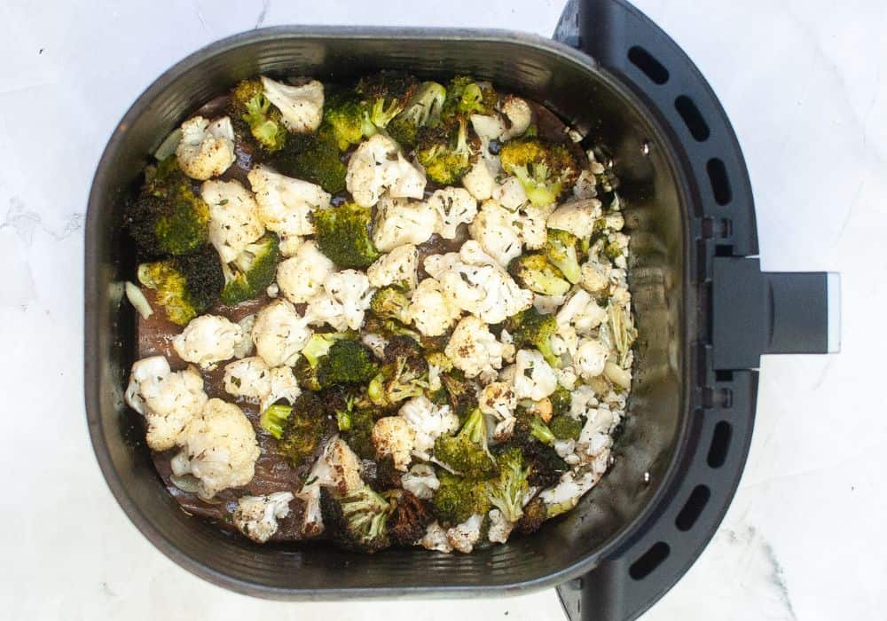 air fried cauliflower and broccoli in an air fryer basket