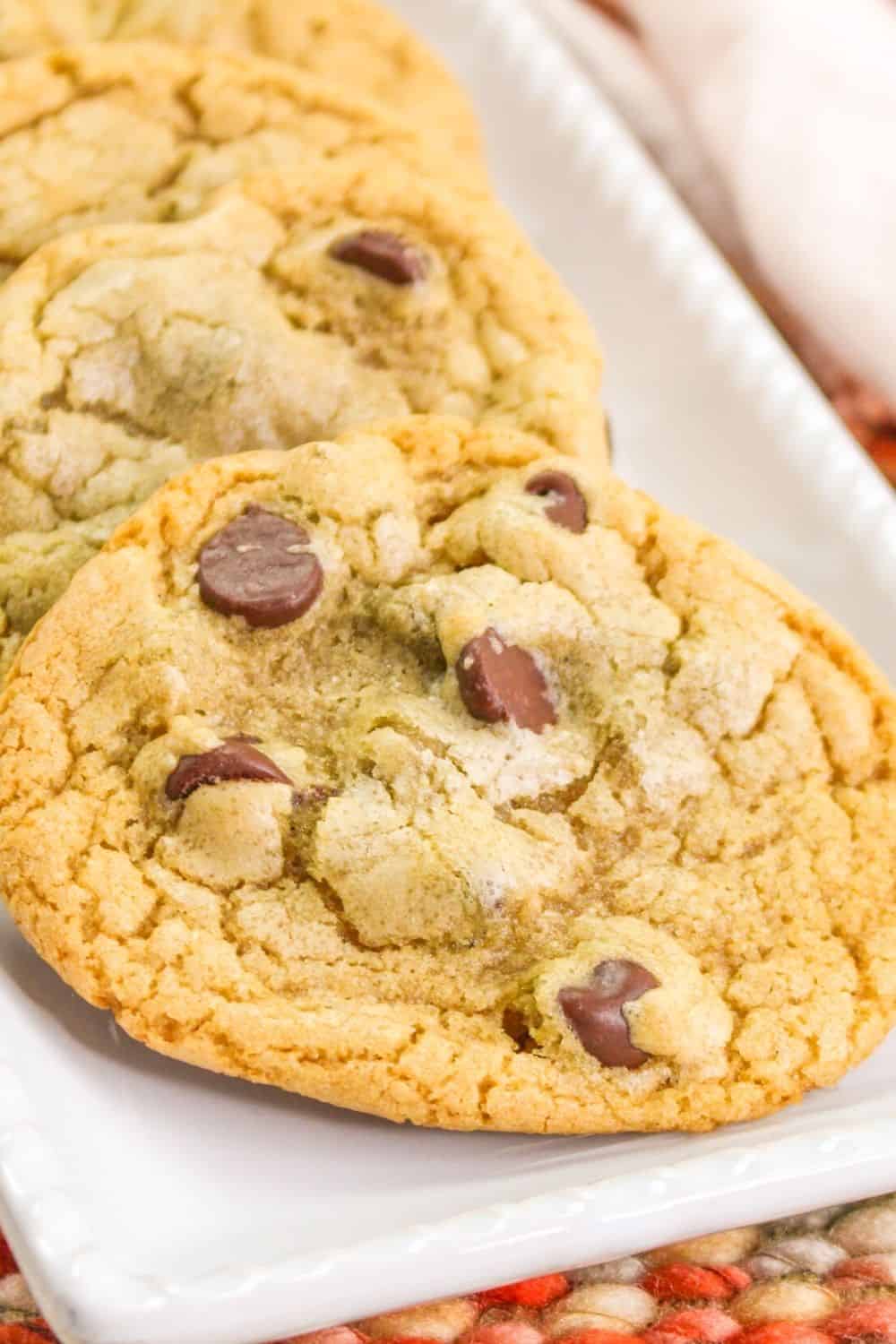 close-up view of a chocolate chip cookie without butter, served on a white rectangular plate.