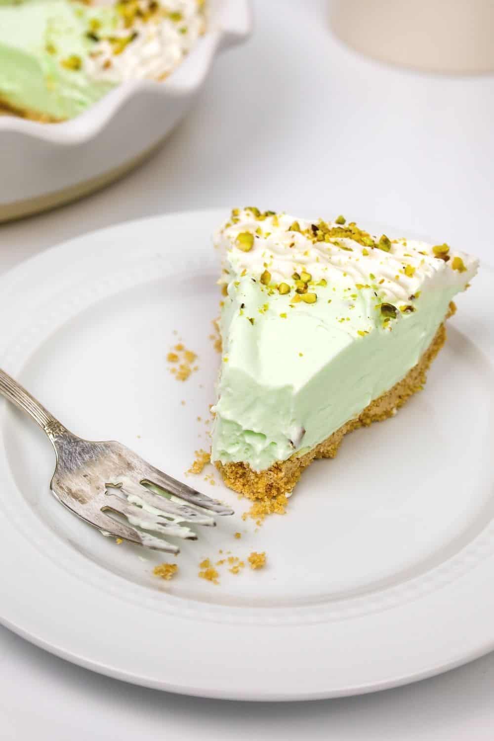 a slice of no bake pistachio pie with a bite taken out of it