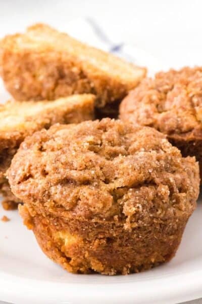 close-up view of pear muffins on a white plate, showing the streusel topping.
