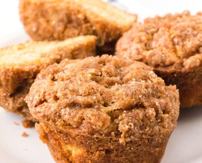 close-up view of pear muffins on a white plate, showing the streusel topping.