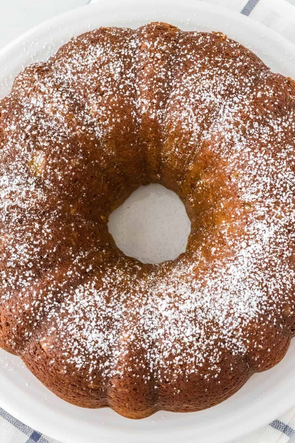 overhead view of pistachio bundt cake dusted with powdered sugar and served on a white plate