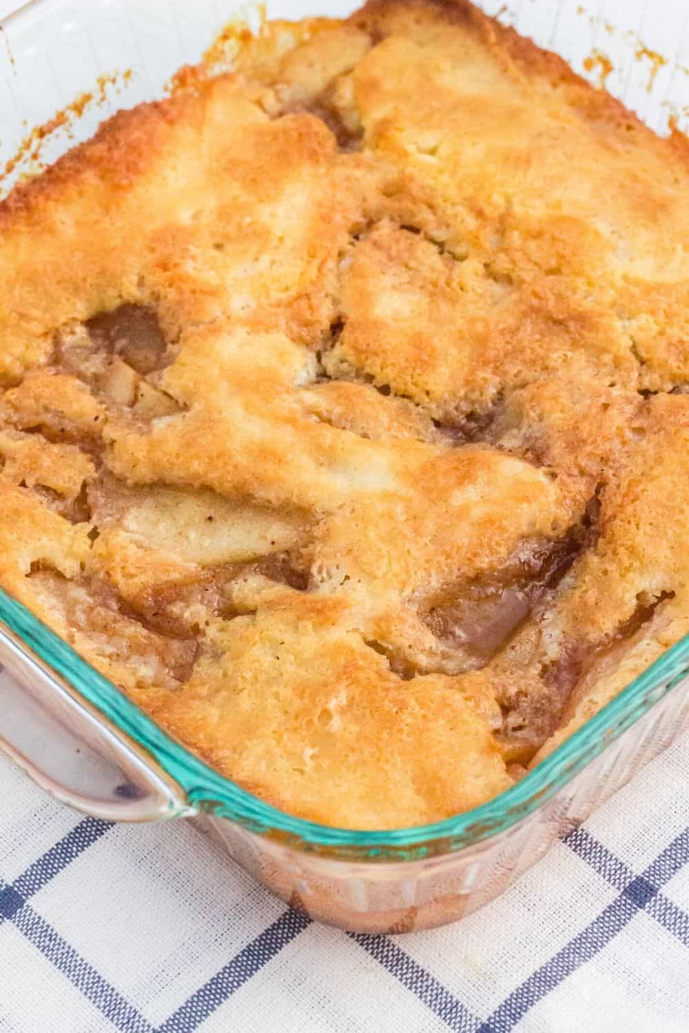 freshly baked pear cobbler in a glass baking dish, setting on a blue and white checkered cloth napkin.