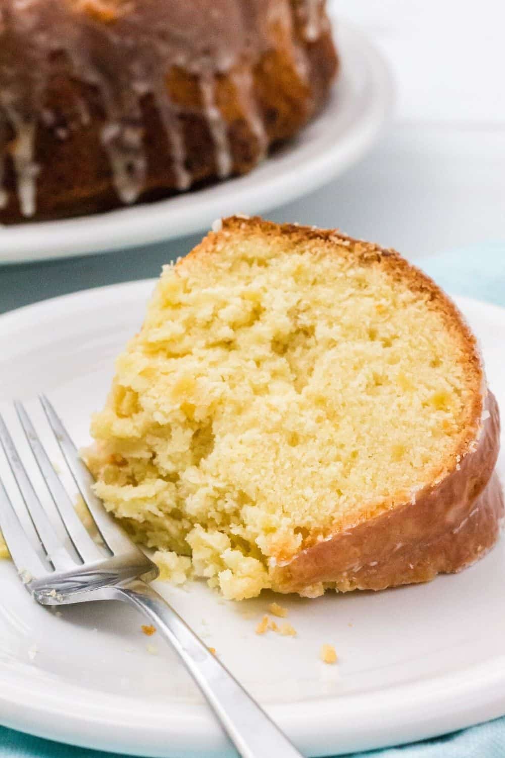 close-up view of a piece of pineapple pound cake with a bite taken out of it, served on a plate with a fork