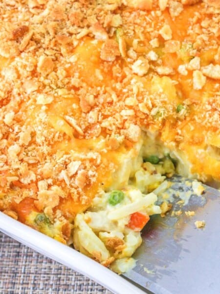 a spatula scoops out a serving of chicken hash brown casserole from the pan