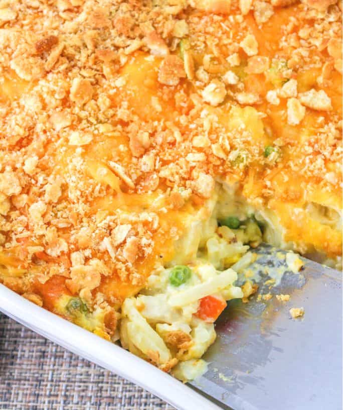 a spatula scoops out a serving of chicken hash brown casserole from the pan