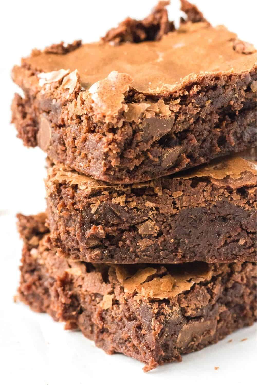 close-up side view of a stack of homemade triple chocolate brownies