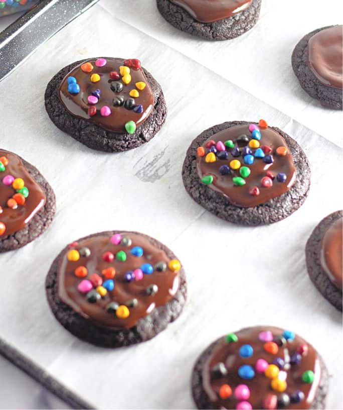 several Cosmic Brownie cookies on a parchment lined baking sheet