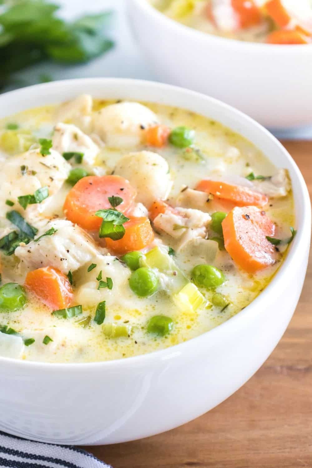 white bowl with homemade chicken and dumplings soup in it