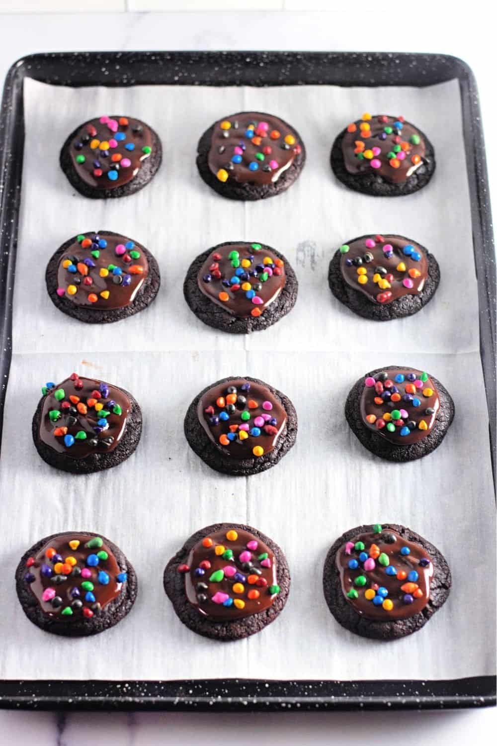 parchment lined baking sheet with cosmic brownie cookies on it