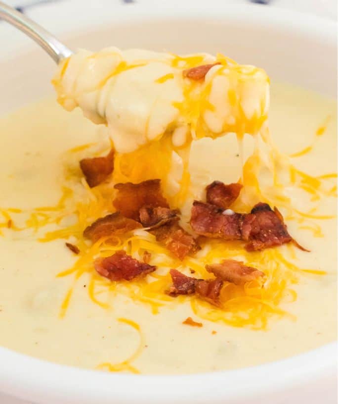 hash brown potato soup with melted shredded cheese and crumbled bacon on top.