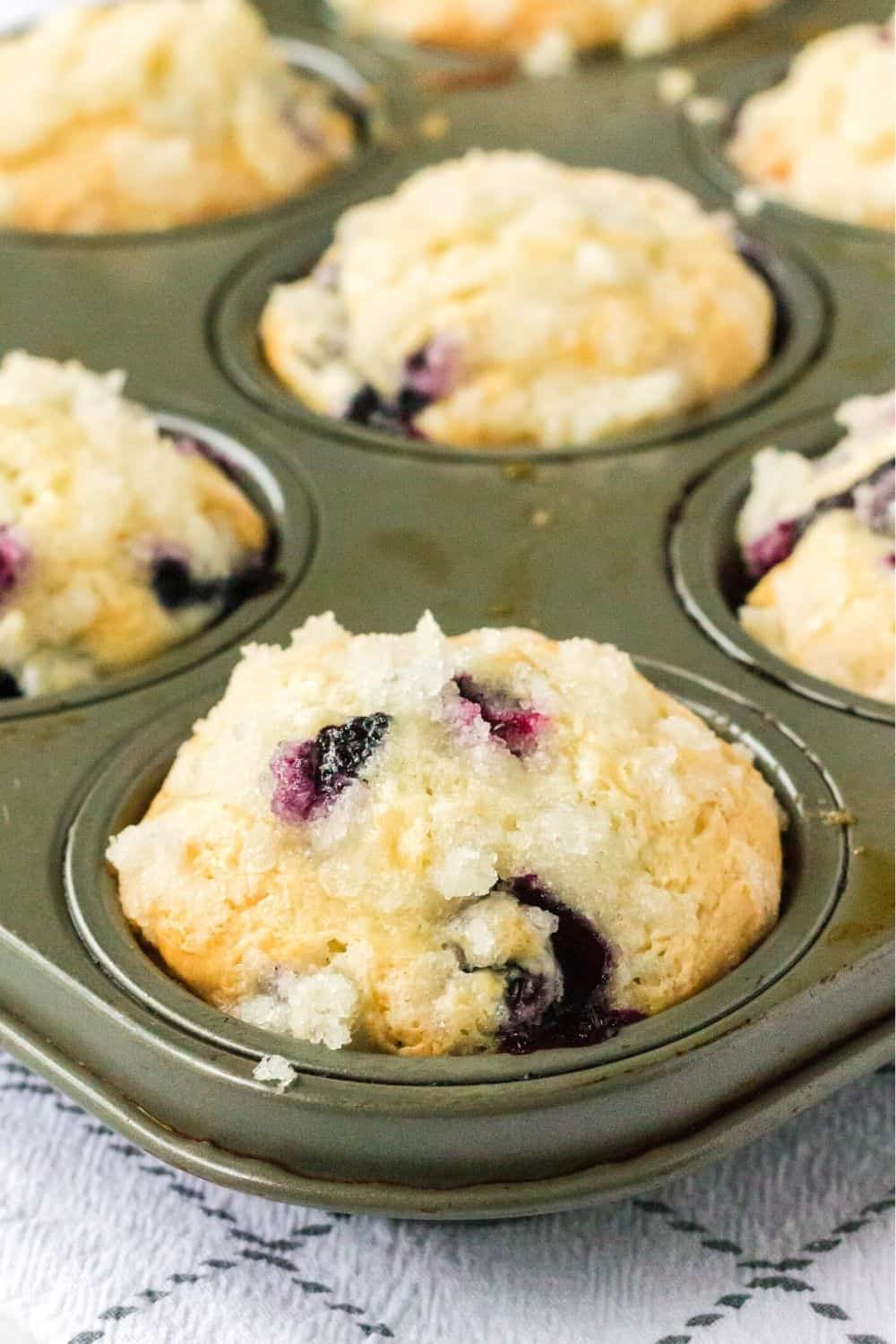 streusel-topped blueberry muffins made with Bisquick, freshly baked and still in the muffin pan.