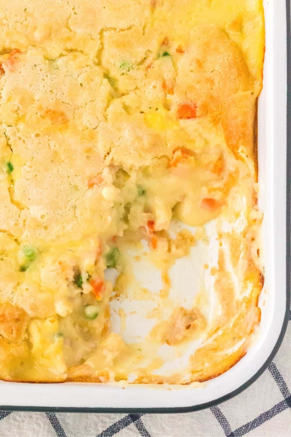 overhead view of a pan of cobbler-like chicken pot pie casserole, with some of the cobbler scooped out