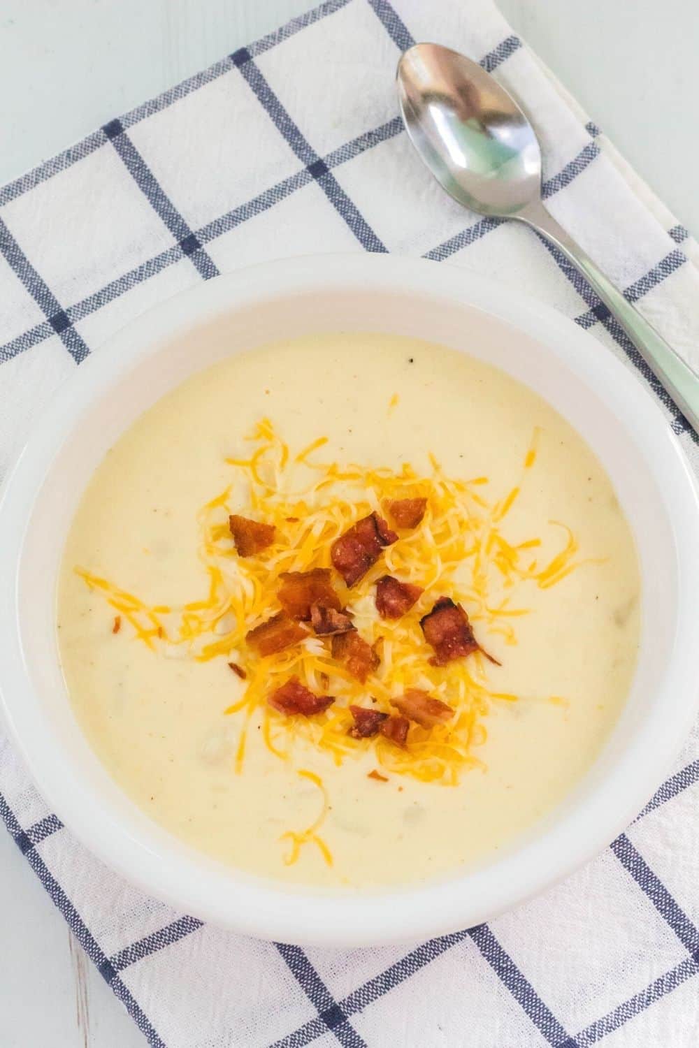 overhead view of a white bowl serving creamy potato soup made with frozen hash browns.