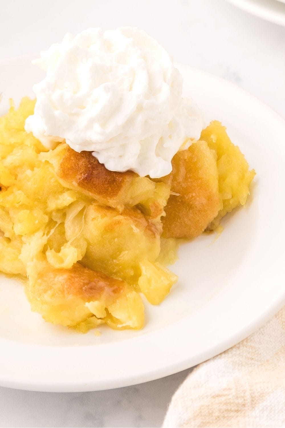 scalloped pineapple stuffing served with a dollop of whipped cream, as a sweet side dish for ham or an easy dessert