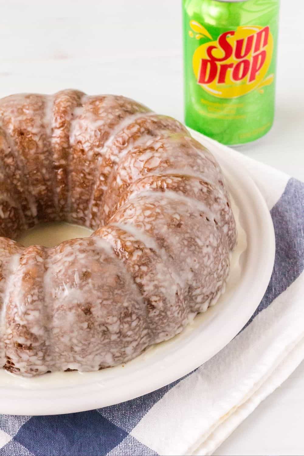 Glazed southern Sun Drop bundt cake on a white plate, with a can of Sundrop in the background.