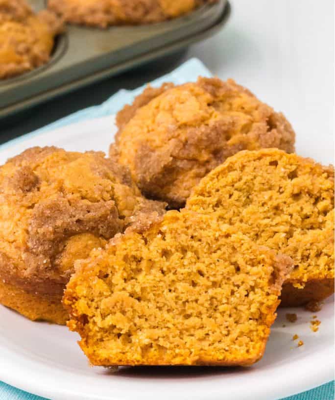 close-up view of sweet potato Bisquick muffins that have been cut in half, showing the moist interior and streusel topping