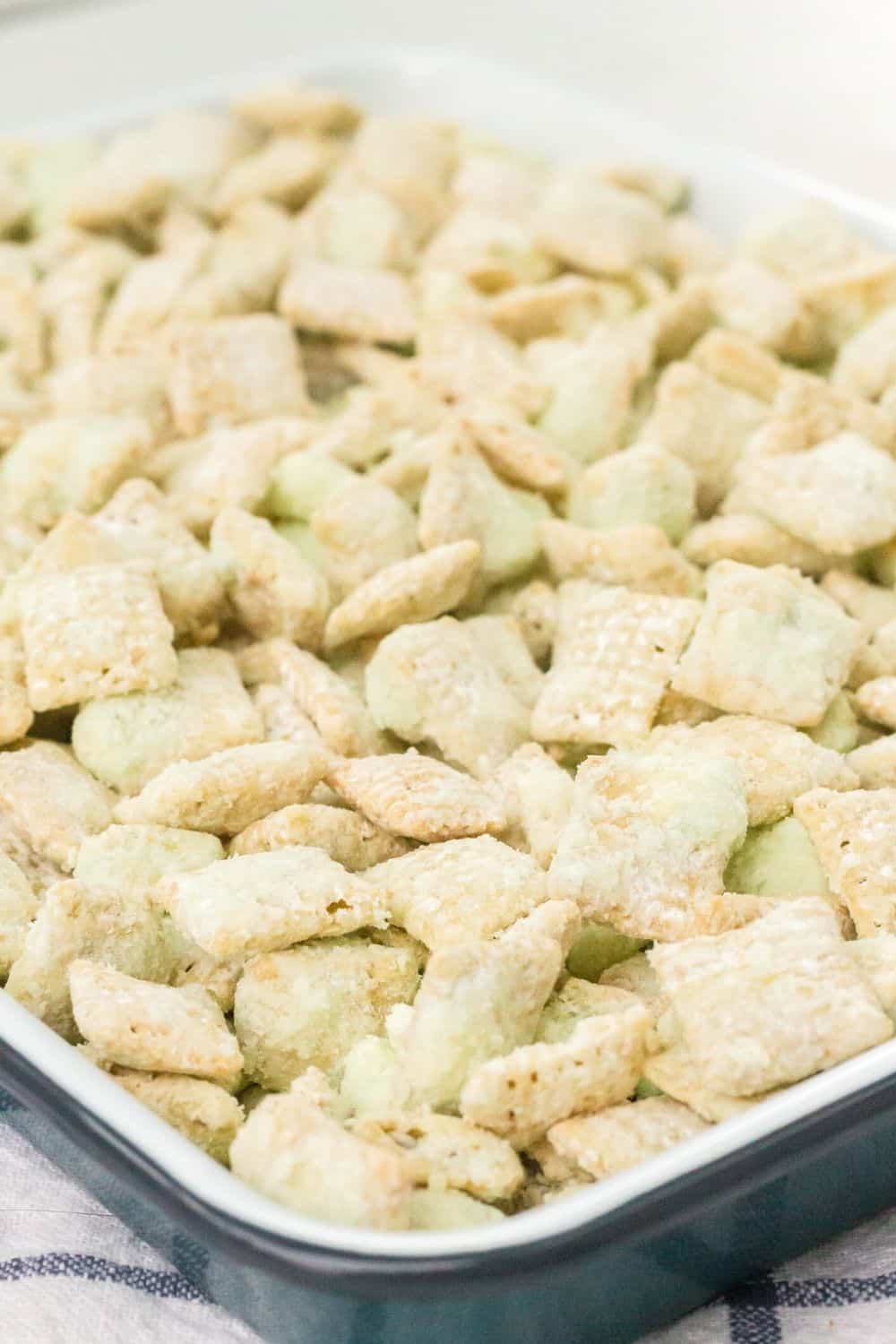 close-up view of a sheet pan filled with pistachio puppy chow mix