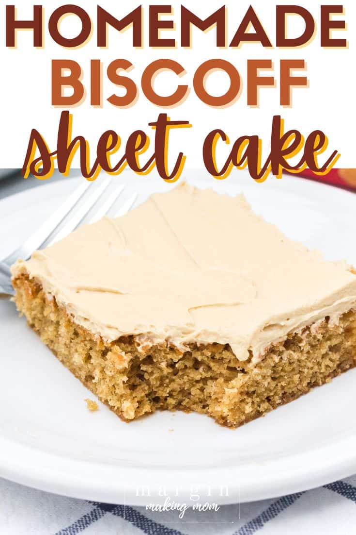 a slice of Biscoff cake topped with cookie butter frosting, served on a white plate with a fork. A bite is taken out of the cake.