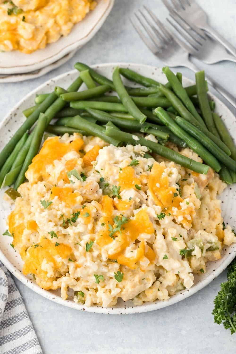 speckled white plate serving cream of chicken and rice casserole and green beans.