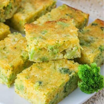 several squares of broccoli cheese cornbread served on a white plate
