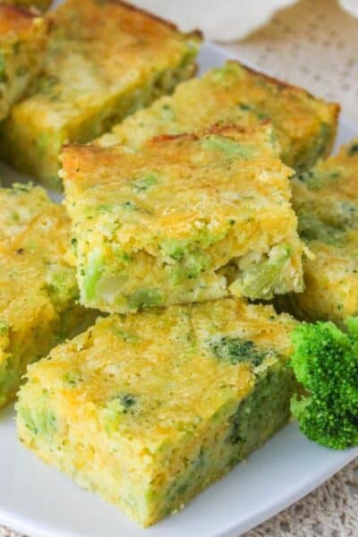 several squares of broccoli cheese cornbread served on a white plate