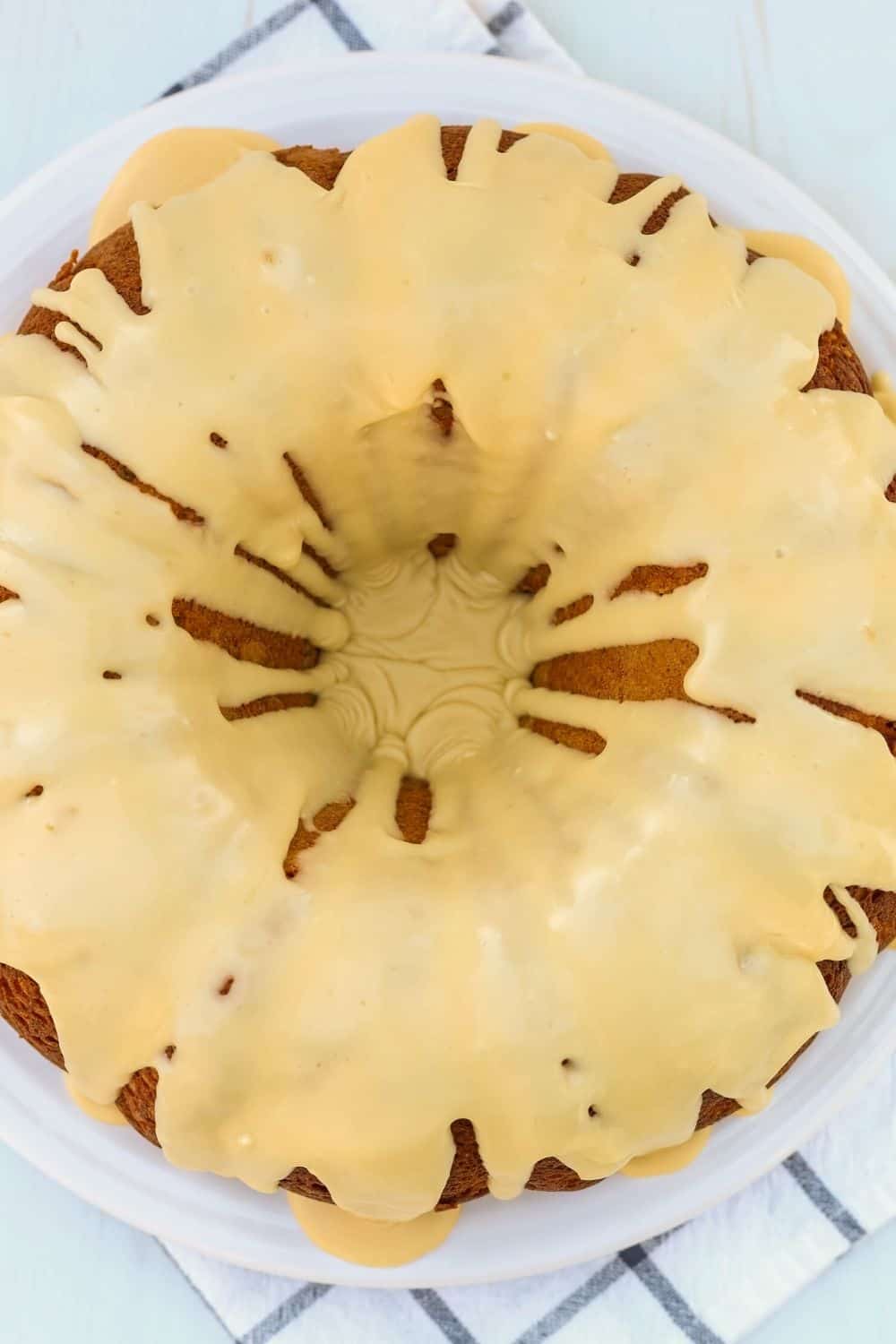overhead view of a whole cake mix pear bundt cake with icing, served on a white plate